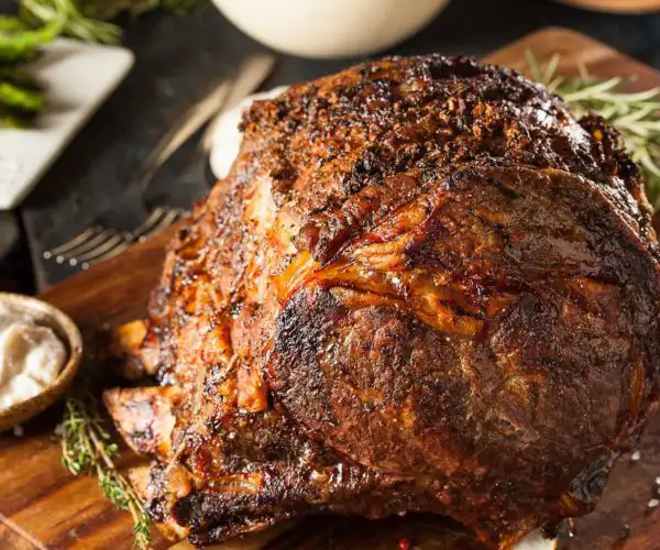 Une généreuse côte de bœuf rôtie, une des recette élaborée par la cheffe de la Table de 3 de Bordeaux, avec une croûte caramélisée, servie sur une planche en bois avec du romarin, des asperges grillées et une sauce crémeuse au raifort.